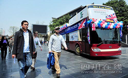 在寬窄巷子，幾位外國游客從世博大巴旁經(jīng)過